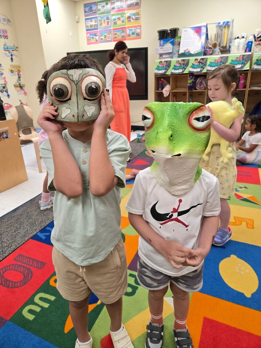 Two preschoolers wearing frog and toad masks