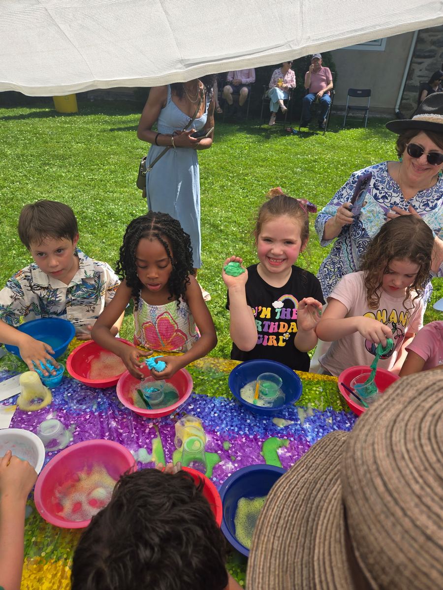 Children mixing colorful slime in bowls